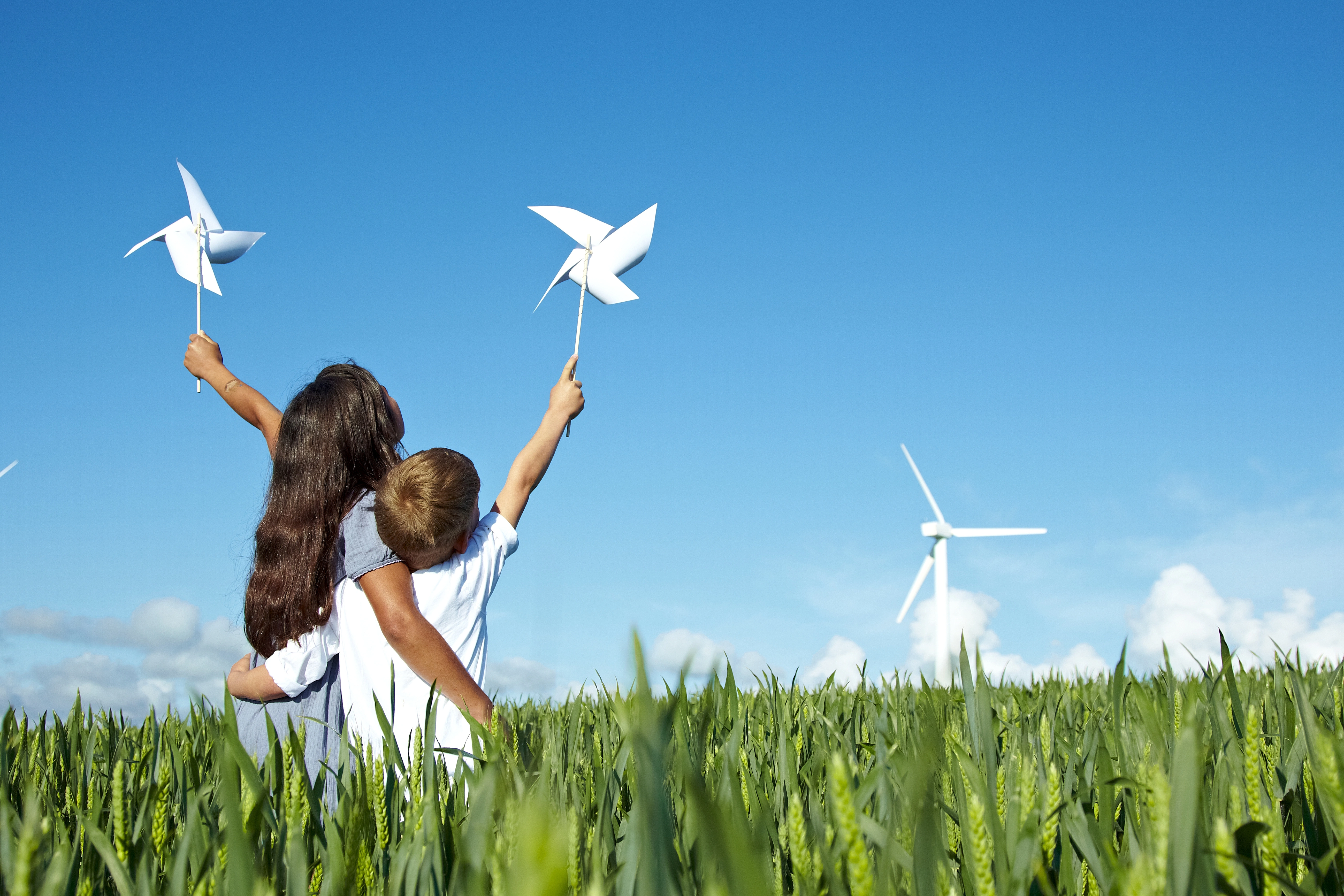 Kinder halten Windmühlen auf dem Feld